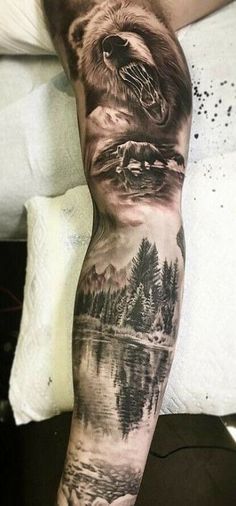 a man's arm with a bear and mountain scene tattoo on the left leg