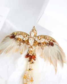 a brooch with feathers and jewels on it