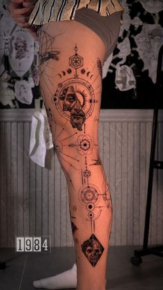 a woman's legs with tattoos on them and an image of a clock in the middle