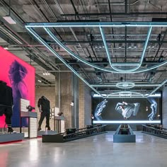 the interior of a clothing store with mannequins and neon lights hanging from the ceiling