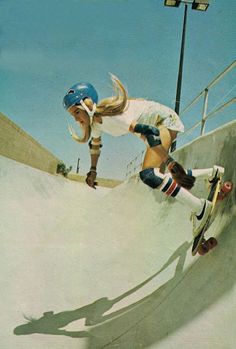 a woman riding a skateboard up the side of a ramp