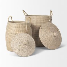 three woven baskets with handles on each side, one is round and the other has two smaller