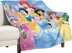 there are many princesses on this blanket that is sitting on the couch with it's back turned