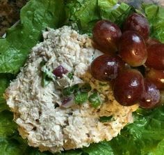 grapes and chicken salad on lettuce leaves with dressing in the middle, ready to be eaten