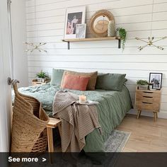 a bedroom with white walls and wood flooring has a green bed spread on it