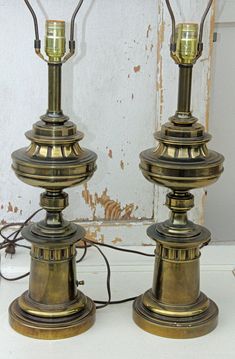 two old fashioned lamps are sitting next to each other