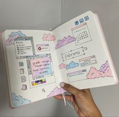 a hand holding an open notebook with doodles on the pages and clouds in it