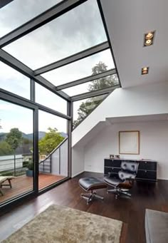 an open living room with wooden floors and large windows on the side of the wall