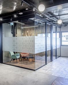 an office with glass walls and chairs in the middle, surrounded by concrete flooring