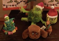 the grinch family is sitting on the table with their stuffed animals and presents in front of them