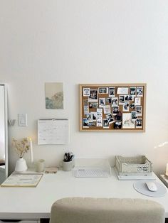 a white desk topped with a laptop computer next to a wall covered in pictures and photos