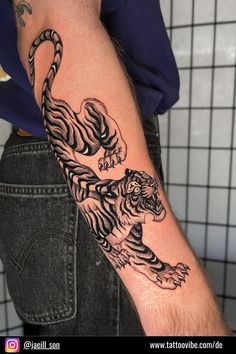 a man with a tiger tattoo on his arm is holding onto another person's arm