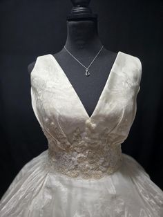 a white wedding dress on a mannequin with a black back and neckline