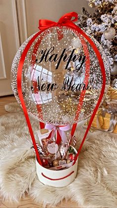 a basket filled with candy and candies sitting on top of a white rug next to a christmas tree