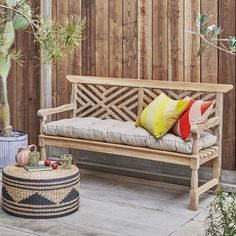 a wooden bench sitting next to a potted plant