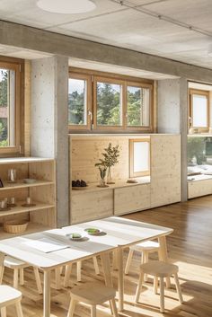 an empty room with tables, shelves and windows on the wall in front of them