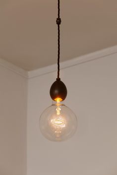 a light bulb hanging from a ceiling in a room with white walls and wood trim