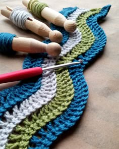 three crocheted wooden pegs on top of a blue and green doily