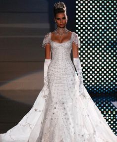 a woman in a white wedding dress on a runway