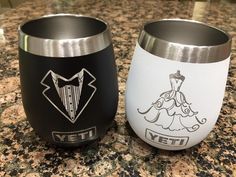 two black and white yeti cups sitting on top of a counter