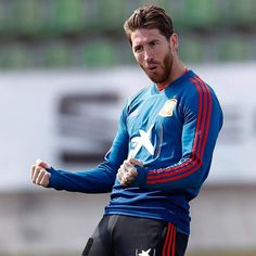 a man in blue jersey holding a soccer ball