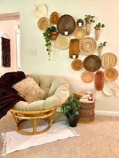 a living room filled with lots of wicker baskets and plants on the wall next to a chair