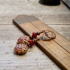 These colors just drew me in! They are so rich and beautiful together. I now have a whole selection of beads that will mix and match with this series. When I look at these, I initially think fall or autumn, then I gravitate to considering Christmas. These items are all available with antique brass or copper. Every earring is available with titanium ear wire, if you need them for your sensitive ears. Even if you don't need them, they look and feel great. These long dangle earrings are perfect for Red Drop Clip-on Earrings As Gift, Red Drop Clip-on Earrings For Gift, Red Dangle Clip-on Earring, Red Dangle Single Clip-on Earring, Handmade Red Plug Earrings As Gift, Artisan Red Dangle Earrings, Red Adjustable Beaded Earrings For Pierced Ears, Red Single Earring As Gift, Artisan Red Pierced Jewelry