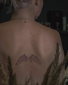 the back of a woman's shoulder with two wings on it