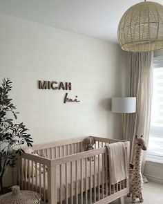 a baby's room with a crib, lamp and stuffed animal in it