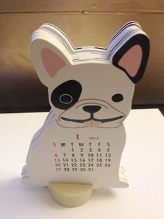 a small calendar with a dog face on it's front cover, sitting on top of a table