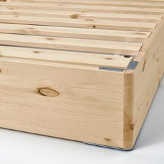 a wooden bed frame with no headboard and slatted sides, on a white background