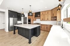 a large kitchen with an island in the middle and lots of cabinets on both sides