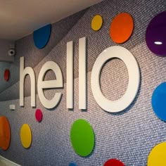 an office wall with colorful circles and the word hello painted on it's side