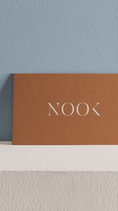 a wooden sign with the word nook on it sitting on top of a shelf