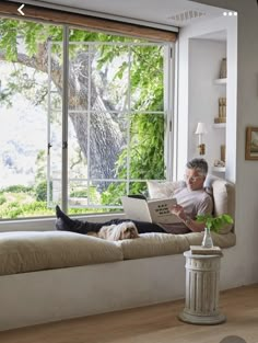 a man sitting on a window sill using a laptop computer