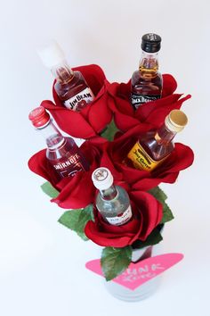 a vase filled with liquor bottles and roses