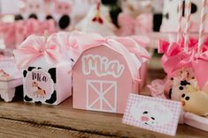 a table topped with pink and white boxes filled with cake next to other items on top of a wooden table