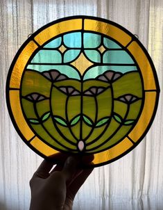 a hand holding up a stained glass window