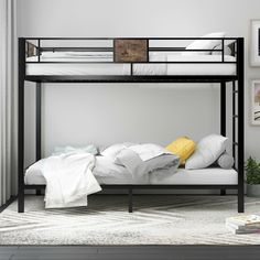 a black metal bunk bed with white sheets and pillows on it's bottom shelf