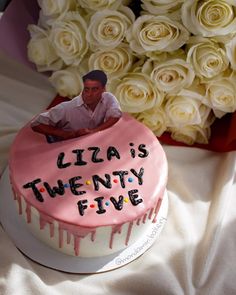 a birthday cake with a man's face on it and flowers in the background