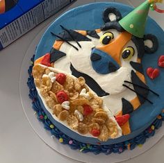 a birthday cake that looks like a cat with a party hat on it's head