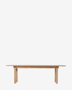 a wooden table sitting on top of a white wall