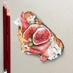 a piece of bread with figs and cheese on it next to a pencil