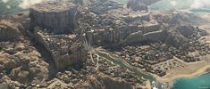 an aerial view of a city on the edge of a cliff overlooking water and land