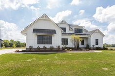 a large white house sitting on top of a lush green field