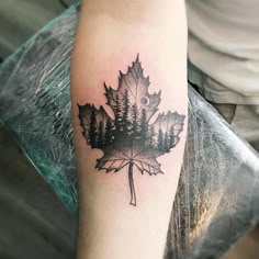 a black and white photo of a leaf with trees on it's back arm