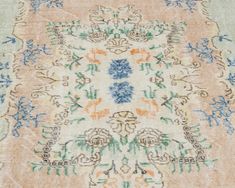 an old rug with blue, orange and green flowers on the bottom is shown in close up