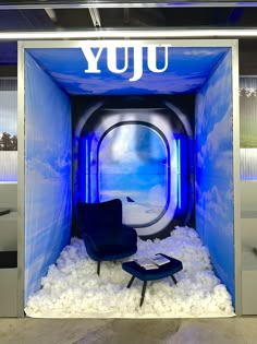 a blue room with an airplane window and chair in the center surrounded by white foam