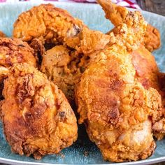 fried chicken on a blue plate sitting on a wooden table