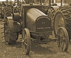 an old tractor is parked in the grass